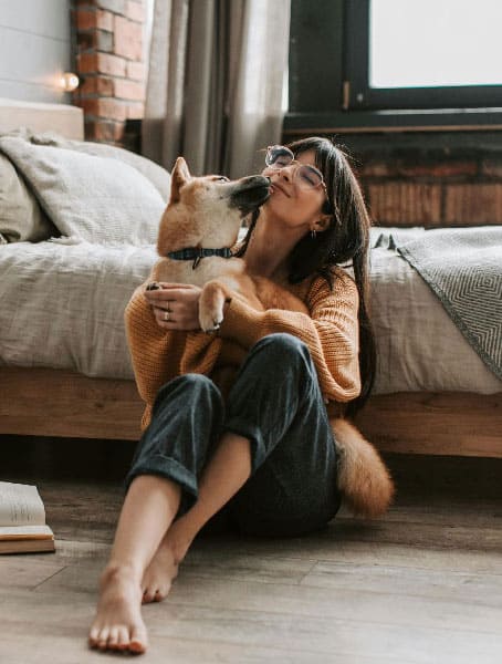 An image of a dog and a woman cuddling, after successful St. Augustine dog training